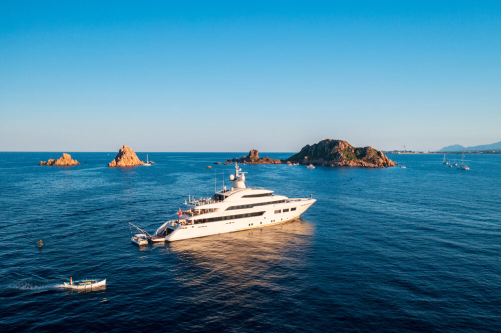 Luxury yacht sailing in the turquoise sea with Isola d'Ogliastra in the background, Lotzorai, Sardinia, Italy